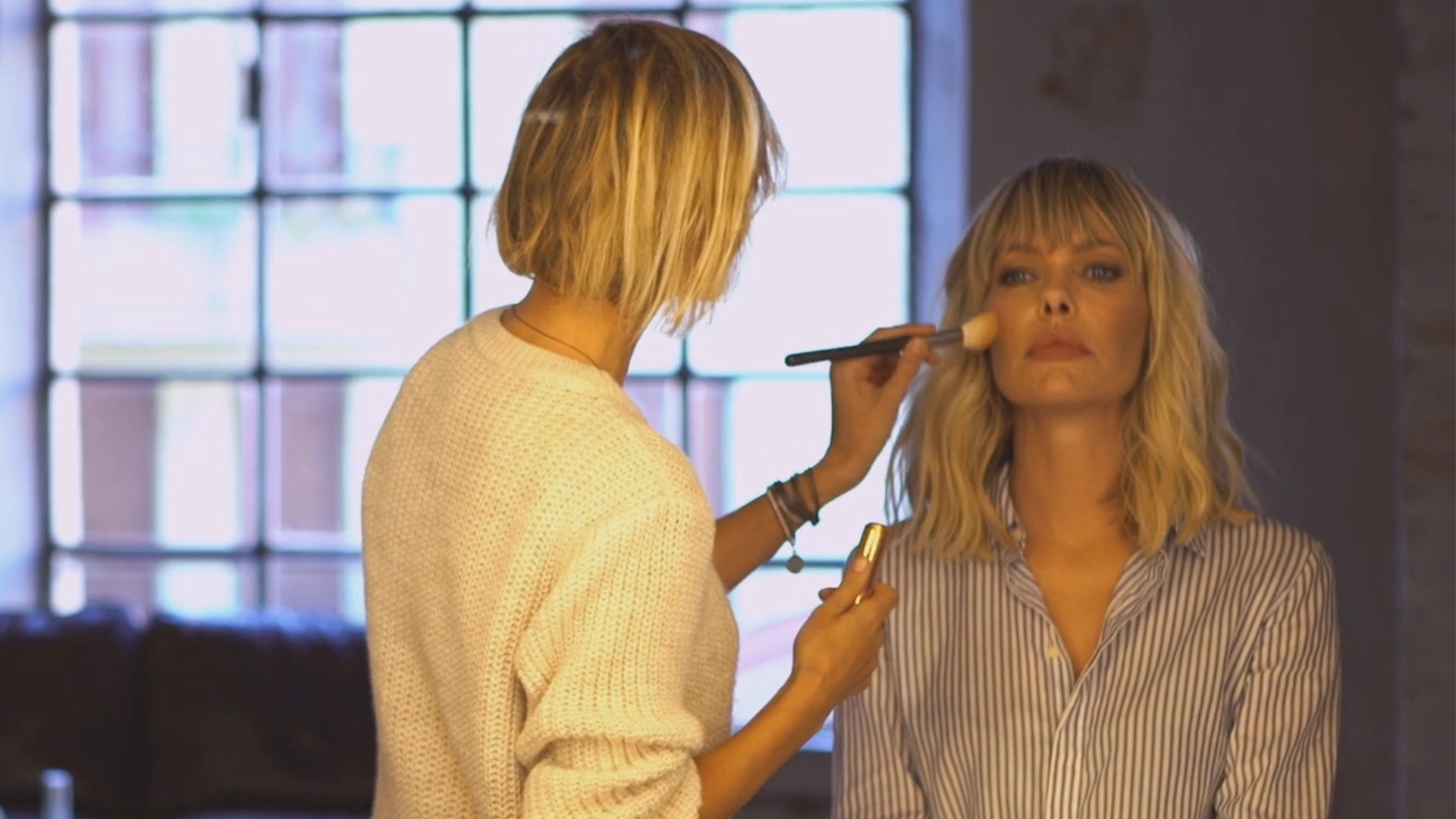 Frame tratto da un commercial per dei prodotti beauty, con makeup artist che opera su una donna